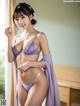 A woman in a purple lingerie posing for a picture.