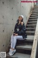 A woman sitting on the steps of a concrete building.