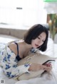 A woman laying on a bed looking at her phone.