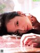 A woman laying on top of a wooden table.