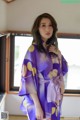 A woman in a purple kimono posing for a picture.