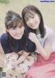 A couple of young women sitting on top of a wooden bench.