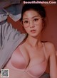 A woman wearing glasses and a pink bra.