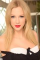 A woman with long blonde hair wearing a black and white dress.