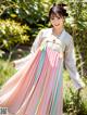 A woman in a pink and blue hanbok is posing for a picture.